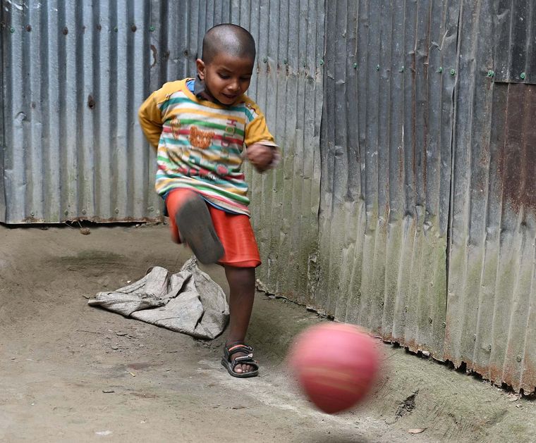 Junge in Bangladesch spielt Fußball