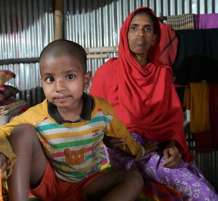 Kind mit Mutter in ihrem Haus in Bangladesch